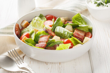 Healthy Organic BLT Bacon Salad with Lettuce and Tomato closeup on the plate on the table. Horizontal