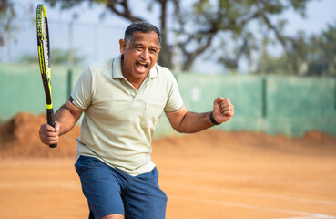 Indian angry frustrated senior man after losing or defeating tennis match - concept of unhappy,...