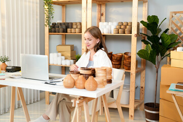 Caucasian young entrepreneur female happy smile when promote vase and coaster handmade product on e-commerce website and now get a first sell order