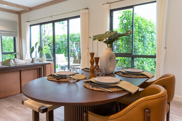 Interior design of modern dining room, wooden table and brown chairs, scandinavian home decoration.