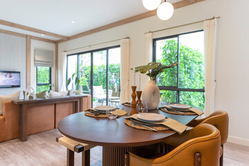 Interior design of modern dining room, wooden table and brown chairs, scandinavian home decoration.