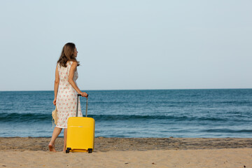 woman on the beach with suitcase