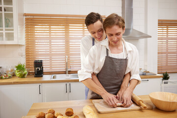 LGBT gay couple making a bread together in the kitchen