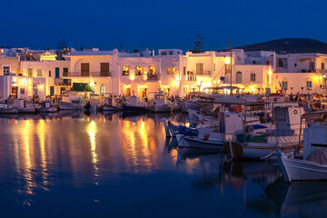 Traditional Greek fishing village and harbour after sunset, boats