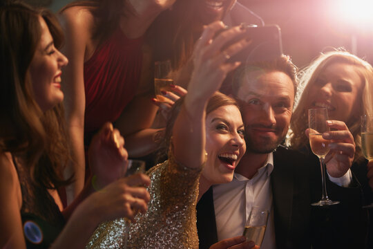Selfie, party and new year with friends in a nightclub posing for photograph of celebration together. Champagne, toast and nightlife with a group of people taking a picture in a club while dancing