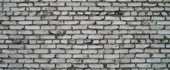 Grayscale backdrop with old realistic white brick wall. Minimal fragment of brickwall close-up. Minimalist monochrome background with wall of gray bricks in different shades. Simple wall texture.