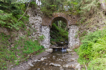 Old arched stone abandoned half-destroyed railroad bridge in Carpathians