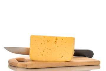 A piece of cheese with a metal knife on a wooden kitchen board, macro, isolated on a white background.