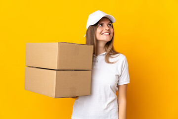 Young Slovak delivery woman isolated on yellow background thinking an idea while looking up