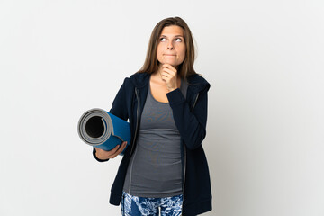 Obraz premium Slovak girl going to yoga classes isolated on white background having doubts and thinking