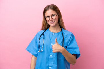 Young surgeon doctor woman isolated on pink background giving a thumbs up gesture