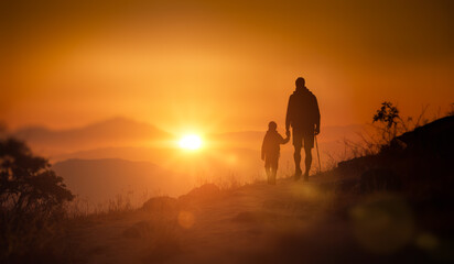 Fototapeta na wymiar father and son in mountains at sunset. backlit. Happy father and son hiking at sunset mountains. Walk towards to goals and achievements
