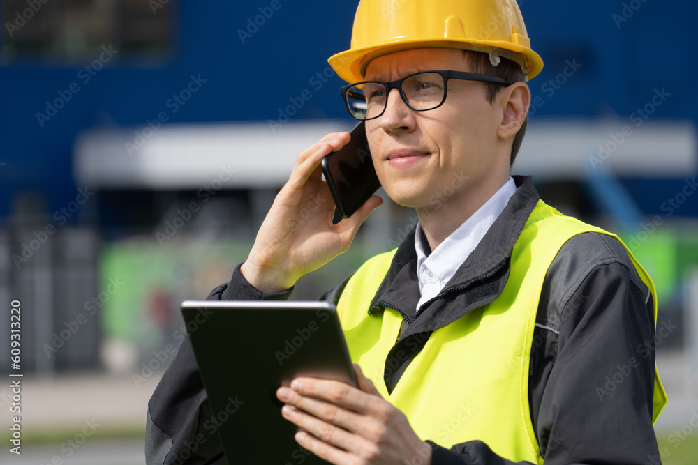 Poster Worker with phone and digital tablet on a background of logistic center	