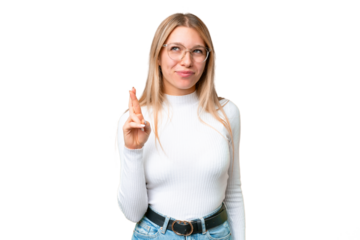 Young pretty blonde woman over isolated chroma key background with fingers crossing and wishing the best