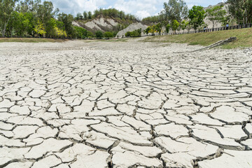 Dry lake bed with the natural texture of cracked clay on the perspective land. 