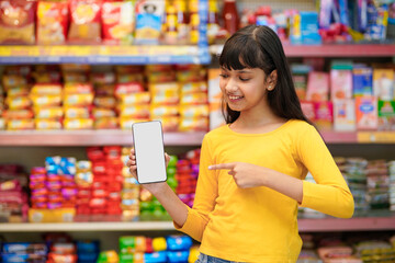 Indian girl showing smartphone screen at supermarket