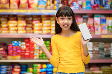 Indian girl showing smartphone screen at supermarket