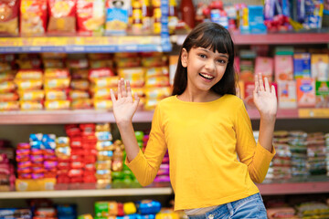 Indian girl giving expression with hand at grocery shop.