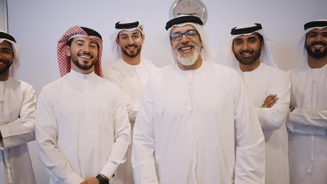 Business men from dubai working in an office. Business people of the emirates wearing the traditional white kandura outfit