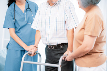 Contented senior man was helped on folding walking by his wife and caregiver. Recuperation for...