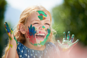 Happy, little girl covered in paint and outdoors with a lens flare. Happiness or creative, playing...