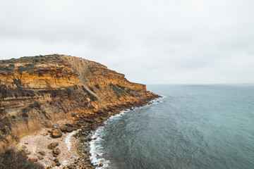 Mountainous coastline of Portugal's southern peninsula in the famous tourist region of the Algarve. The rocky cliffs around the town of Luz. Discovering the Fisherman trail, Rota Vicentina