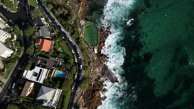 People swimming in Bronte Baths ocean pool with waves crashing.