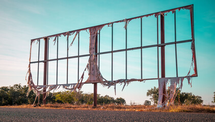 A billboard in the Northern Territory (Australia) with only vestiges of what once was an...