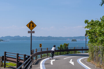 A cyclist rides round a bend on the Shimanami Kaido cycling road in Ehime, Japan