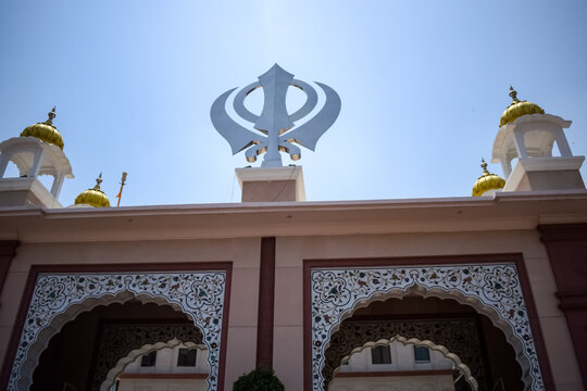 Khanda Sikh holy religious symbol at gurudwara entrance with bright blue sky image is taken at Sis Ganj Sahib Gurudwara in Chandni Chowk, opposite Red Fort in Old Delhi India