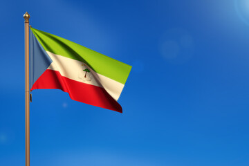 Ecuatorial Guinea. Flag blown by the wind with blue sky in the background.