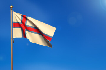 Faroe Islands. Flag blown by the wind with blue sky in the background.