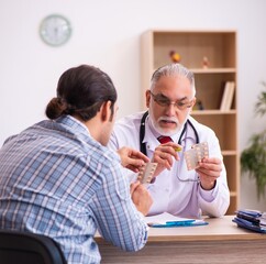 Young male patient visiting aged male doctor
