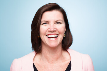 Happy, portrait of mature woman smile and against a blue background for health wellness. Happiness, mock up space and excited or cheerful female person smiling with pose against a studio backdrop