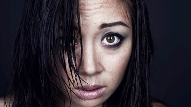 Face, scared and woman with fear, nervous and worried girl against a dark studio background. Portrait, female person or model with stress, depression or afraid with anxiety, terror feeling or anxious
