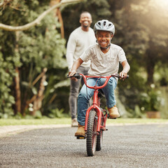 Boy with smile on bicycle, father and learn cycling with help, helmet for safety and family in...