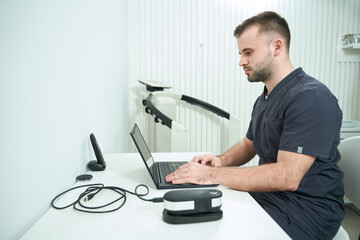 Specialist nutritionist sits at a workplace at a laptop