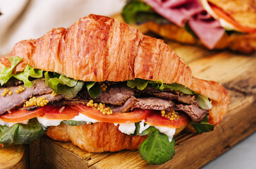 croissant with boiled pork and tomatoes