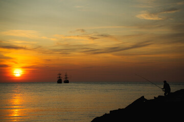 Statki oraz Rybak na morzu bałtyckim przy zachodzie słońca miejscowość rowy rok 2021