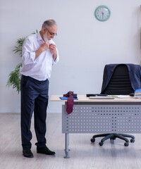Aged male employee doing physical exercises during break