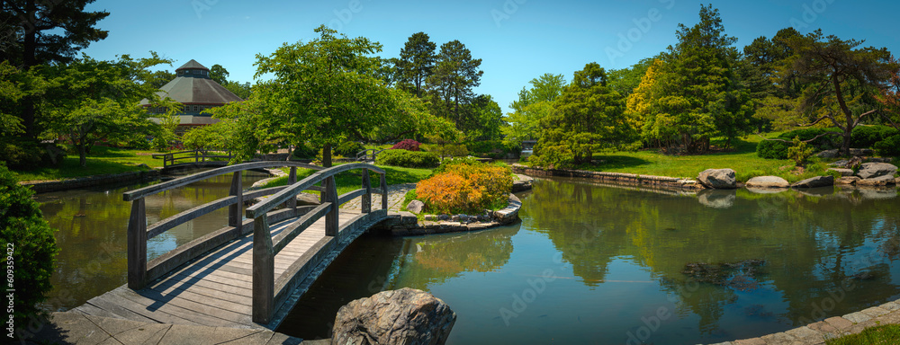 Wall mural Japanese garden with curved footbridge over the pond