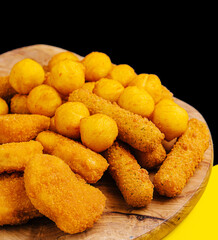 nuggets and cheese balls on wooden board