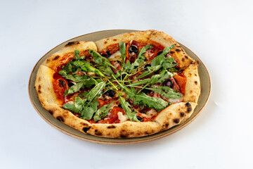 Home made pizza topped with black forest ham, tomatoes, spices, black olives, on white background