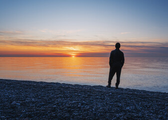 A man standing alone on the beach