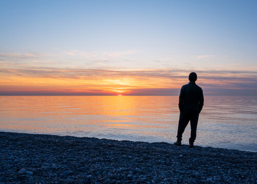 A man standing alone on the beach