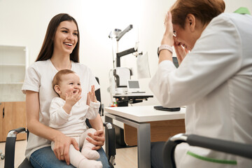 Cheerful young family of two sitting at eye doctor appointment