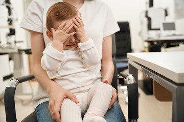 Young patient with parent sitting in ophthalmologist office