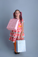 Menina com vestido de festa junina  sorridente com sacolas de compras 