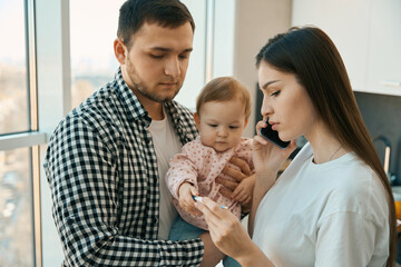 Caring young parents with a sick baby in their arms