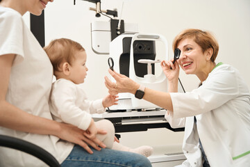 Ophthalmologist performing vision screening in child at initial consultation